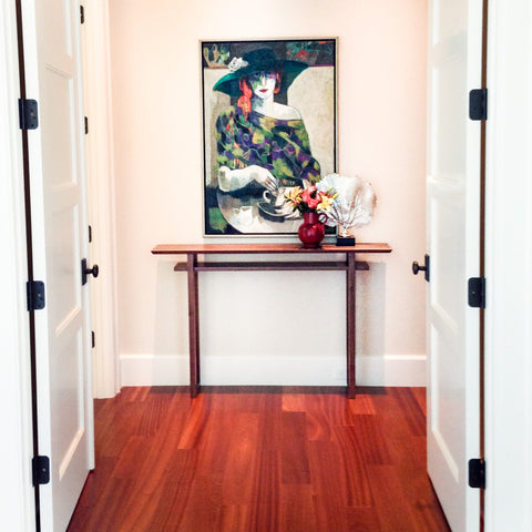 The Classic Console Table by Mokuzai Furniture placed as an entry console table with artwork hanging above.