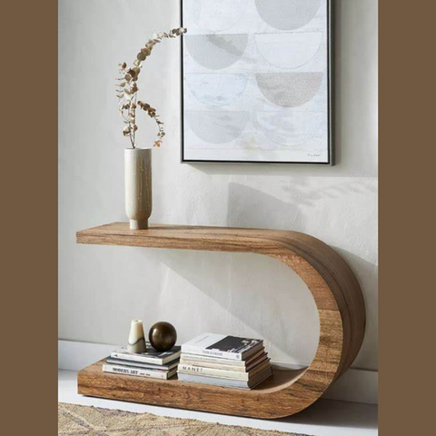 An interesting crescent shaped console table with a minimalist vase of flower stems on one end.