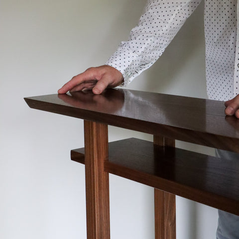 A narrow walnut console table with shelf by Mokuzai Furniture