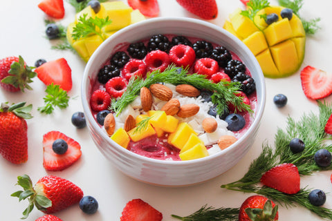 Close-up of a fruit bowl with some almonds on top.