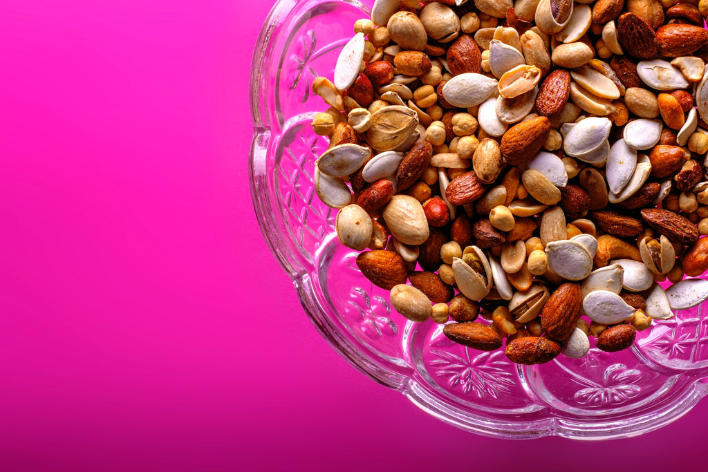 Various nuts in a bowl showcasing how nuts can help you lower cholesterol and prevent diabetes.