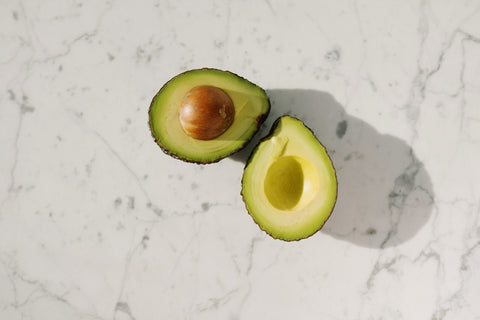 Sliced avocado on a white surface.