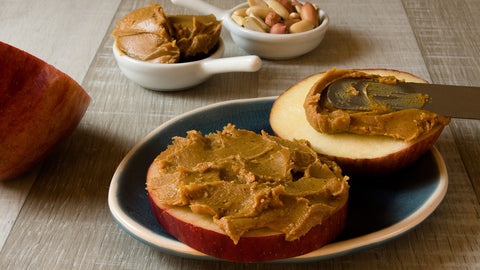 Peanut butter spread on slices of apple.