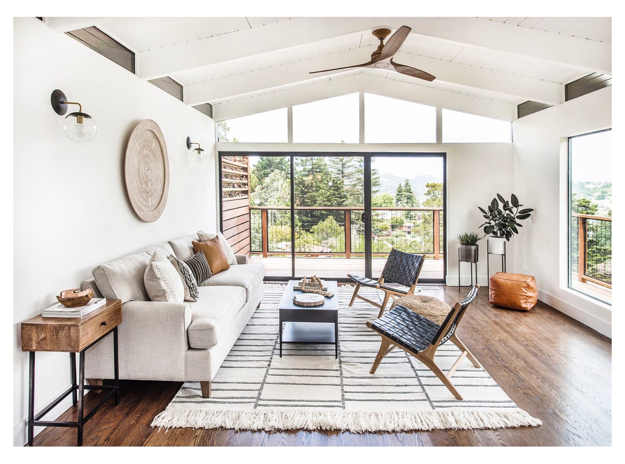 Mid-Century Modern home in Mill Valley, CA. Living room view as you enter the home. Cream sofa with black leather woven lounge chairs