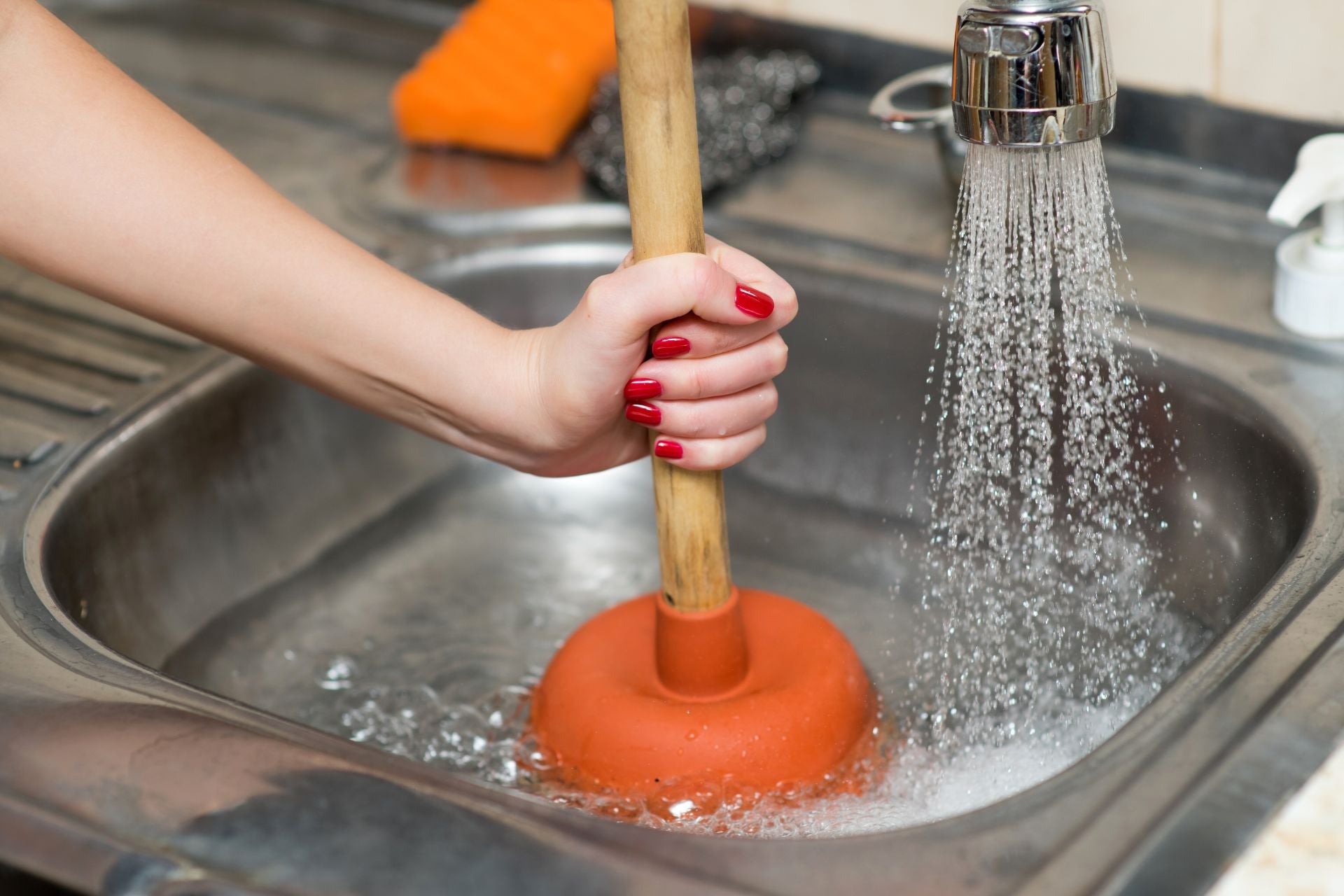 A person plunging their clogged sink