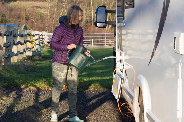 A person filling an RV’s fresh water tank
