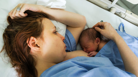 Mutter stillt Säugling nach der Geburt