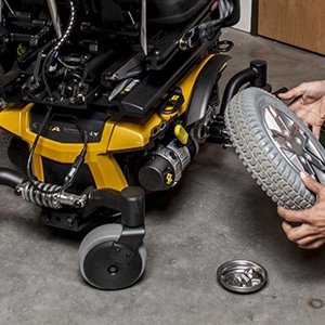 closeup view of the drive wheel being replaced on a yellow power wheelchair