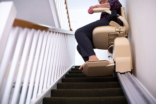 woman using straight stair lift indoors