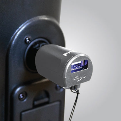 a silver usb charging block is plugged into the charging port on a mobility device