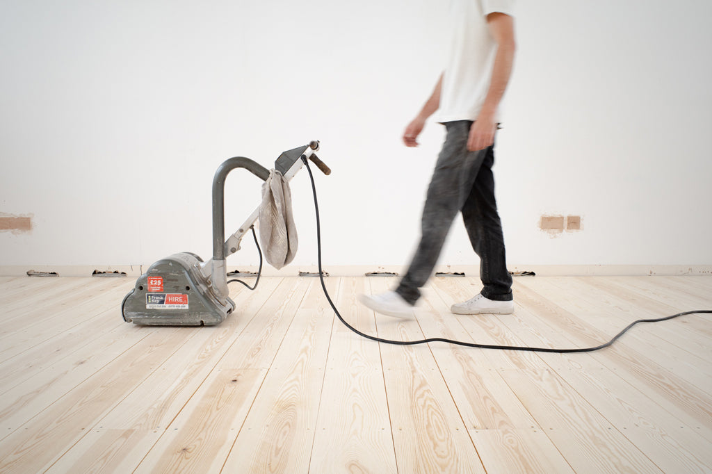 Sanding the pine floorboards