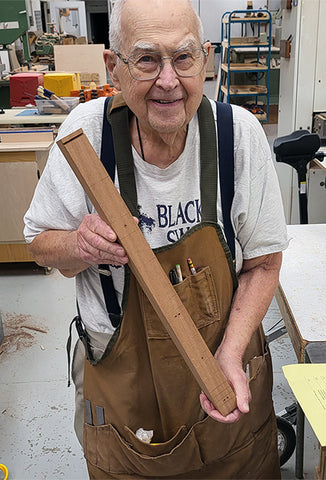 jim ash holding a fretboard neck of a folkcraft lapjo