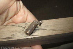 bullet inside a slab of walnut