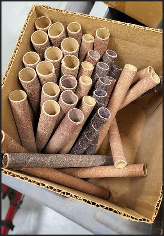 old box full of rolled up sandpaper