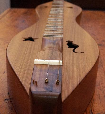 closeup of sound holes mystery possibly folkcraft dulcimer