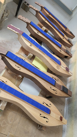 row of folkcraft dulcimers to be lacquered