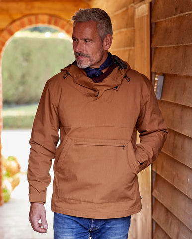 Man wearing Alan Paine Chatbourne Waterproof Smock in tobacco standing in a wooden outdoor building
