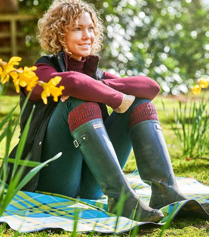 Woman sitting down outside wearing wellies and work socks