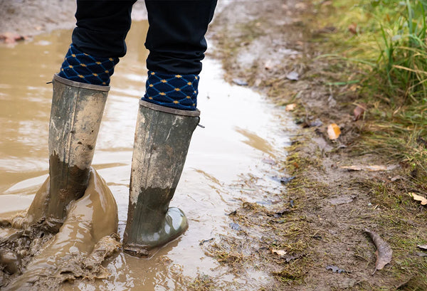 Person wearing Jack Pyke Ashcombe Zipped Wellies to walk through muddy conditions