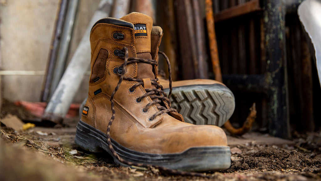 Ariat work boots in tan against a muddy background