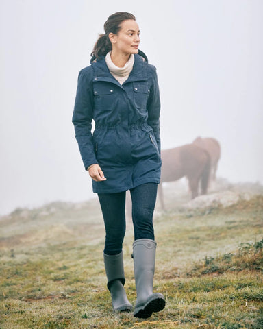 Woman wearing Ariat Womens Kelmarsh Wellington Boots to walk across field