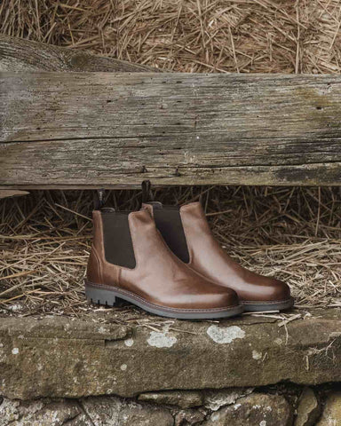 Hoggs of Fife Banff Country Dealer Boots in burnished tan against an outdoor countryside background