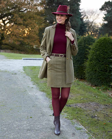 Woman wearing Alan Paine Combrook Mid-Thigh Coat & Skirt in Grove with red jumper and tights outdoors