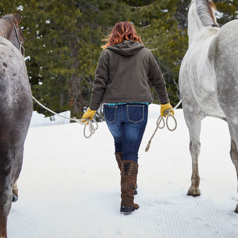 Woman wearing Ariat Langdale Waterproof Leather Boots in java to guide horses through the snow