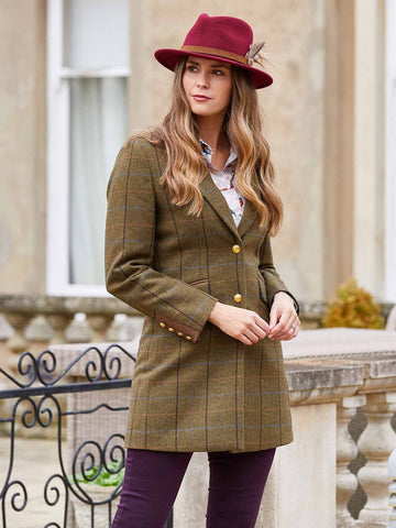 Woman wearing ladies tweed jacket, felt hat, tailored trousers, and button-down shirt
