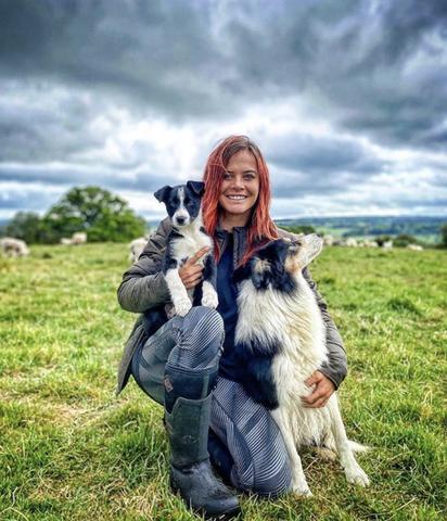 Hannah Jackson - the Red Shepherdess - with her dogs in a field on her farm