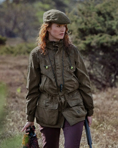 Woman wearing Harkila Orton Packable Lady Jacket in willow green while shooting in the countryside