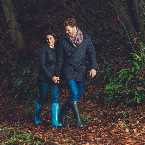 Man and woman wearing Cotswold Sandringham Wellies as they walk through the woods