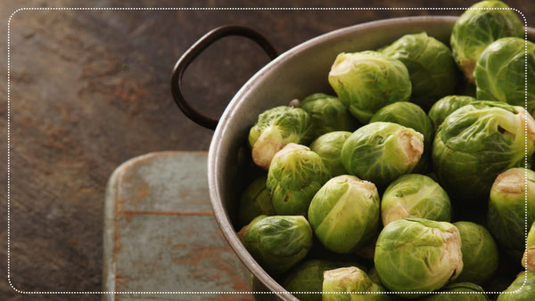 Brussels sprouts in a bowl on a rustic kitchen table