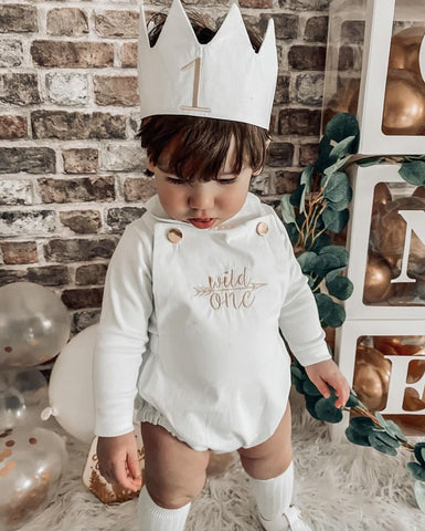 Baby wearing a "wild one" romper and crown during a virtual birthday celebration 