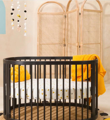 Baby nursery featuring a circular crib and curved lines