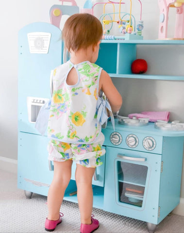 Toddler playing at a toy kitchen