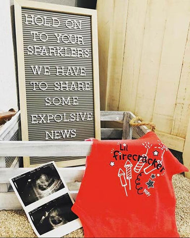 A 4th of July pregnancy announcement letterboard that says "Explosive News" 
