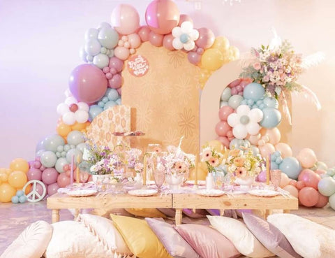 A 70s-themed baby shower decorated with earth-tone balloons and pillows