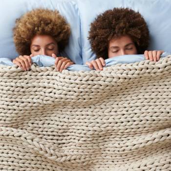 Couple under a Bearaby weighted blanket