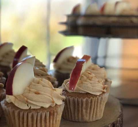 Frosted cupcakes topped with apple slices for a fall baby shower