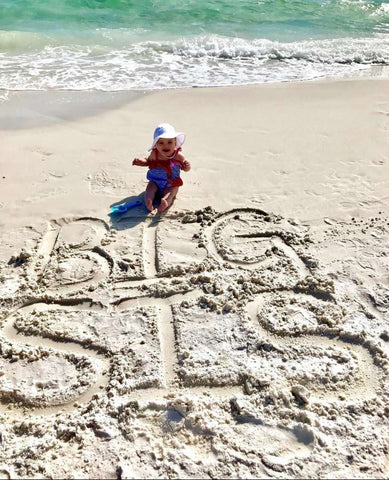 "Big Sis" written in the sand to announce a pregnancy on the beach