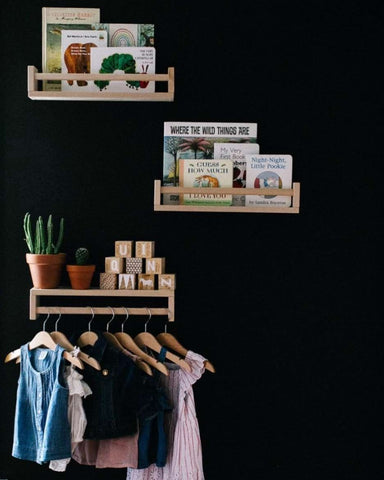 Floating bookshelves on a black nursery wall