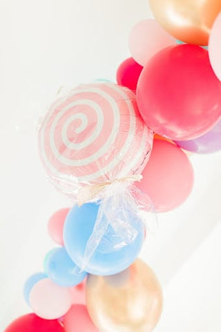 Candy colored balloons, plus one that looks like a striped lollypop for a fall baby shower
