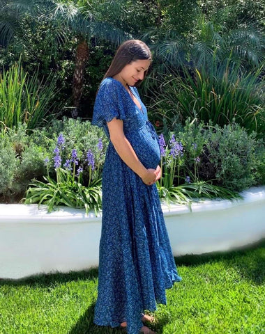 Lea Michele wears a blue dress and cradles her baby bump to announce her pregnancy