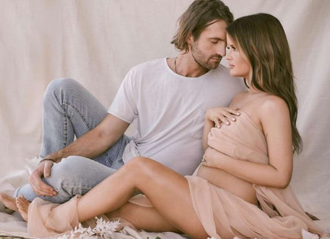 Maren Morris poses with her husband in their pregnancy announcement