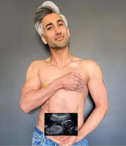 Tan France holds a photo of an ultrasound in his pregnancy announcement