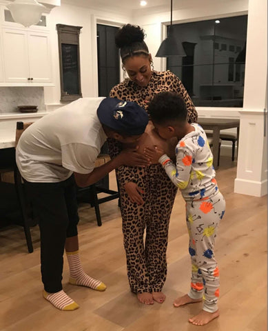 Tia Mowery's pregnancy announcement photo: her husband and child kiss her baby bump