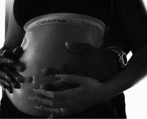 Khloe Kardashian cradles her belly in her pregnancy announcement