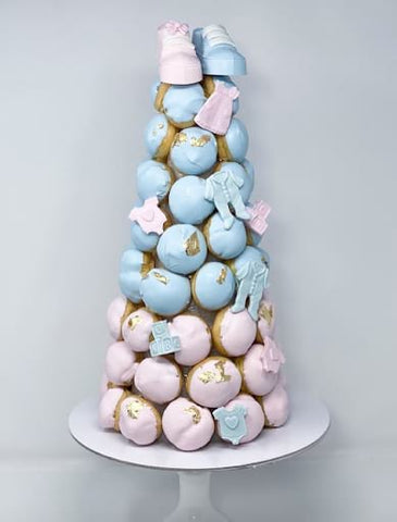 Tower of pink and blue frosted cream puffs.