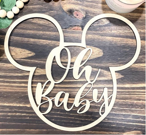 A Mickey Mouse ears cut-out with the words "oh baby" written inside them used for a Disney pregnancy announcement